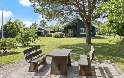 a wooden picnic table and two benches in a park at 3 Bedroom Pet Friendly Home In Højslev in Højslev