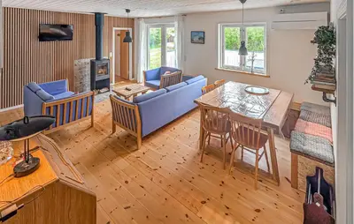 a living room with a blue couch and a table at 3 Bedroom Awesome Home In Vestervig in Vestervig