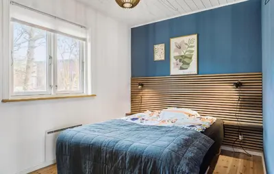 a bedroom with a bed with a blue wall at 3 Bedroom Awesome Home In Vestervig in Vestervig
