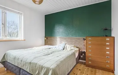 a bedroom with a bed and a green wall at 3 Bedroom Awesome Home In Vestervig in Vestervig