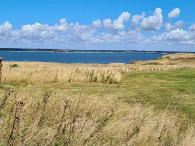a field of grass with a large body of water at 6 person holiday home in Struer-By Traum in Struer