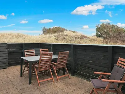 a table and chairs on a patio with a fence at 5 person holiday home in Brovst-By Traum in Brovst