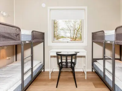 a room with two bunk beds and a table and a chair at 5 star holiday home in Øster Assels-By Traum in Øster Assels