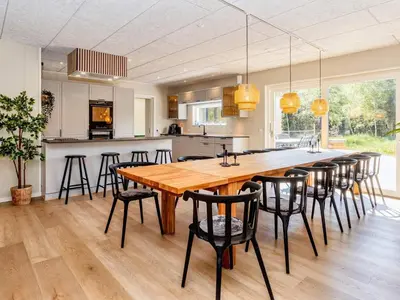 a kitchen and dining room with a large wooden table and chairs at 5 star holiday home in Øster Assels-By Traum in Øster Assels
