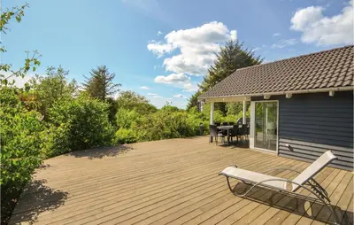 a wooden deck with a chair and a table at Holiday Home Hjerm Gh-1983 in Hjerm