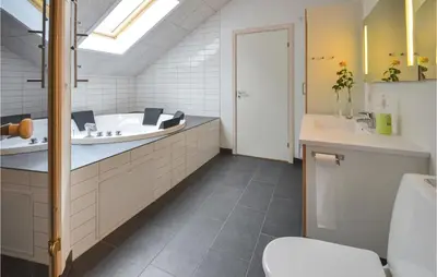 a bathroom with a tub and a sink and a toilet at Holiday Home Hjerm Gh-1983 in Hjerm