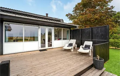 a deck with two chairs and a house at Holiday Home Hurup Thy Ij-1982 in Sønder Ydby