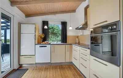 a kitchen with white appliances and a wooden floor at Holiday Home Hurup Thy Ij-1982 in Sønder Ydby