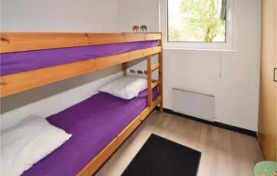 two bunk beds in a room with a window at Holiday Home Farsø Op-1966 in Farsø