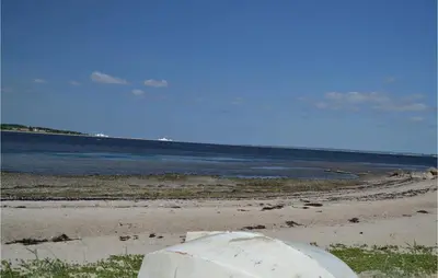 a sandy beach with the ocean in the background at Holiday Home Farsø Op-1966 in Farsø