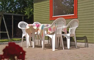 three white chairs and a table in front of a house at Holiday Home Farsø Qr-1965 in Farsø