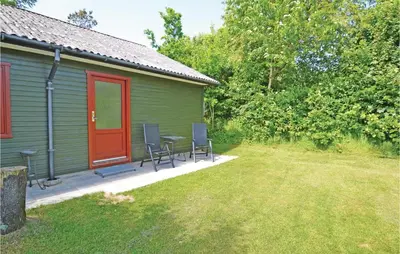a green house with a table and chairs in the yard at Holiday Home Farsø Qr-1965 in Farsø