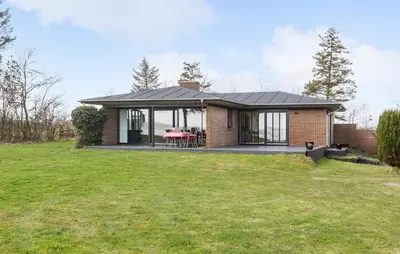a small brick house with a table on a lawn at Awesome Home In Roslev With Kitchen in Roslev