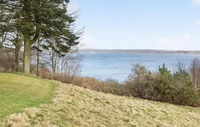 a grassy hill with a view of a body of water at Awesome Home In Roslev With Kitchen in Roslev