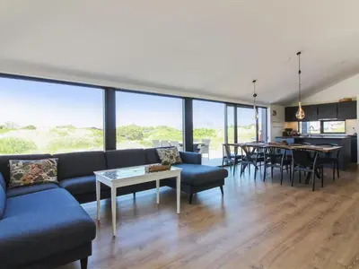 a living room with a blue couch and a table at Holiday Home Kristiina - 500m from the sea by Interhome in Saltum