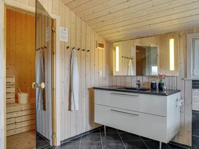 a bathroom with a sink and a mirror at Holiday Home Emelia - 50m from the sea by Interhome in Torsted