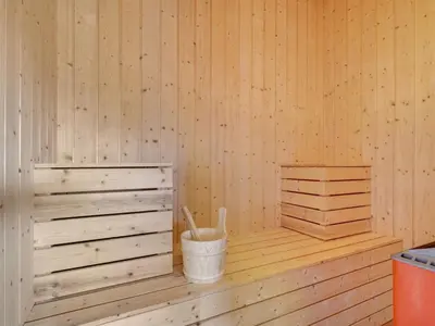 a sauna with a bucket and a broom in it at Holiday Home Emelia - 50m from the sea by Interhome in Torsted