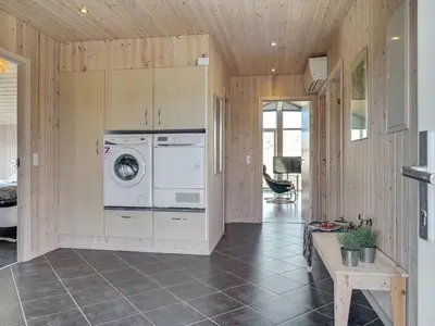 a kitchen with a washer and dryer in a room at Holiday Home Emelia - 50m from the sea by Interhome in Torsted