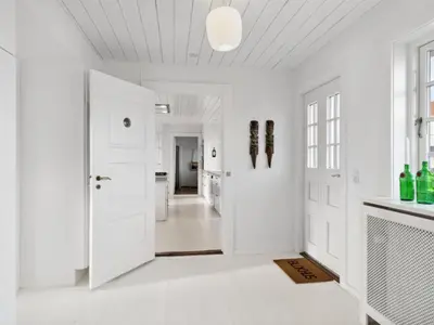 a white hallway with white walls and a ceiling at Holiday Home Jeppe - 200m from the sea by Interhome in Blokhus