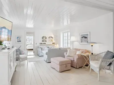 a white living room with a couch and chairs at Holiday Home Jeppe - 200m from the sea by Interhome in Blokhus