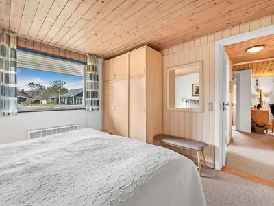 a bedroom with a large bed and a window at Holiday Home Moreen - 200m to the fjord by Interhome in Vemb