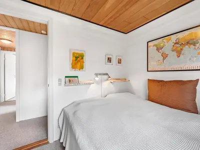 a white bedroom with a bed and a map on the wall at Holiday Home Moreen - 200m to the fjord by Interhome in Vemb