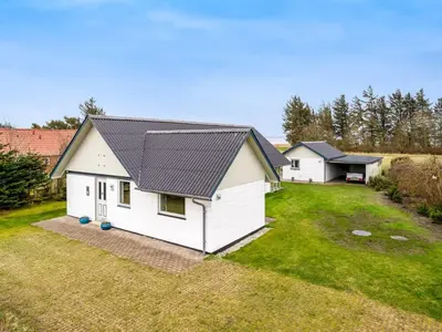 a white house with a black roof on a yard at Holiday Home Moreen - 200m to the fjord by Interhome in Vemb