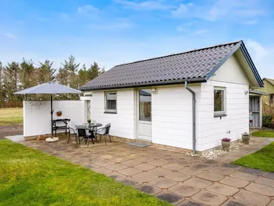 a white shed with a table and chairs at Holiday Home Moreen - 200m to the fjord by Interhome in Vemb
