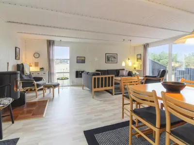 a living room with a table and chairs at Holiday Home Florencia - 450m from the sea by Interhome in Løkken