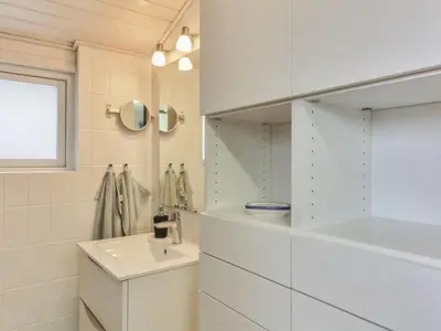 a white bathroom with a sink and a mirror at Holiday Home Florencia - 450m from the sea by Interhome in Løkken