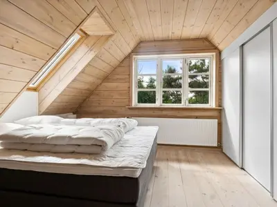 an attic bedroom with two beds and a window at Holiday Home Månviva - 150m to the fjord by Interhome in Redsted