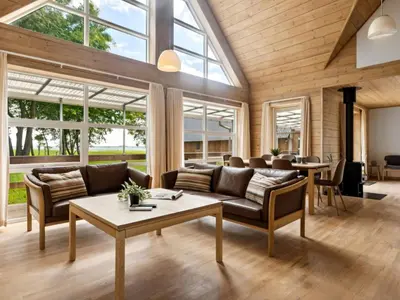 a living room with a couch and a table at Holiday Home Månviva - 150m to the fjord by Interhome in Redsted