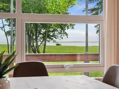 a window in a dining room with a view of the ocean at Holiday Home Månviva - 150m to the fjord by Interhome in Redsted