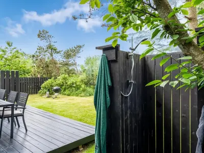 a deck with a fence and a table and chairs at Holiday Home Jukka - 2km from the sea by Interhome in Snedsted