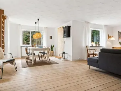 a living room with a table and a couch at Holiday Home Birtir - 750m from the sea by Interhome in Hanstholm