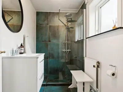 a bathroom with a shower and a sink and a mirror at Holiday Home Birtir - 750m from the sea by Interhome in Hanstholm