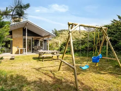 a swing in the yard of a house at Holiday Home Selenia - 1km from the sea by Interhome in Saltum