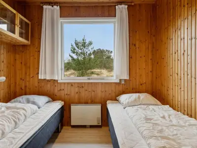 two beds in a room with a window at Holiday Home Swenki - 700m from the sea by Interhome in Saltum