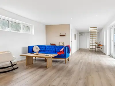 a living room with a blue couch and a table at Holiday Home Ajvi - 900m from the sea by Interhome in Blokhus