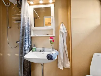 a bathroom with a sink and a mirror and a toilet at Holiday Home Bonde - 800m to the fjord by Interhome in Farsø