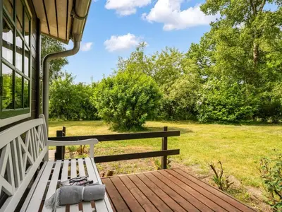 a wooden bench sitting on the porch of a house at Holiday Home Bonde - 800m to the fjord by Interhome in Farsø