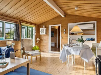 a living room with a table and a dining room at Holiday Home Bonde - 800m to the fjord by Interhome in Farsø
