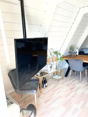 a living room with a large television on a desk at Hyggeligt golfhus i Himmerland in Farsø