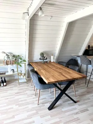 a wooden table in a room with chairs at Hyggeligt golfhus i Himmerland in Farsø