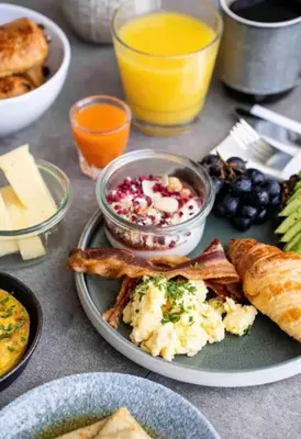 a table with a plate of breakfast food and drinks at Hyggeligt golfhus i Himmerland in Farsø