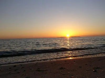a sunset on a beach with the ocean at 4 star holiday home in Løgstør-By Traum in Løgsted