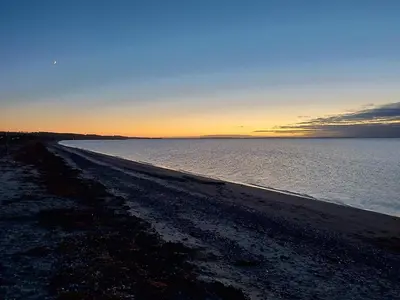 a beach at sunset with the sky and the water at 4 star holiday home in Løgstør-By Traum in Løgsted