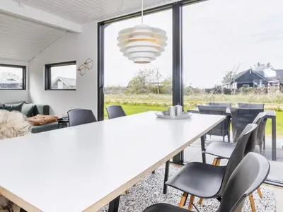 a dining room with a large white table and chairs at 4 star holiday home in Løgstør-By Traum in Løgsted