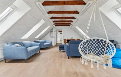 a living room with blue chairs and a swing at Nice Home In Spøttrup With Sauna in Spottrup