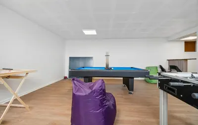 a room with a ping pong table and a purple chair at Nice Home In Spøttrup With Sauna in Spottrup